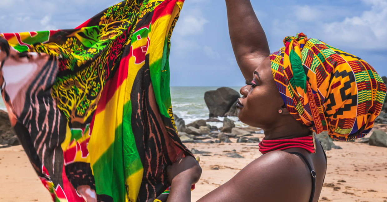 A West African woman holds colorful fabric.