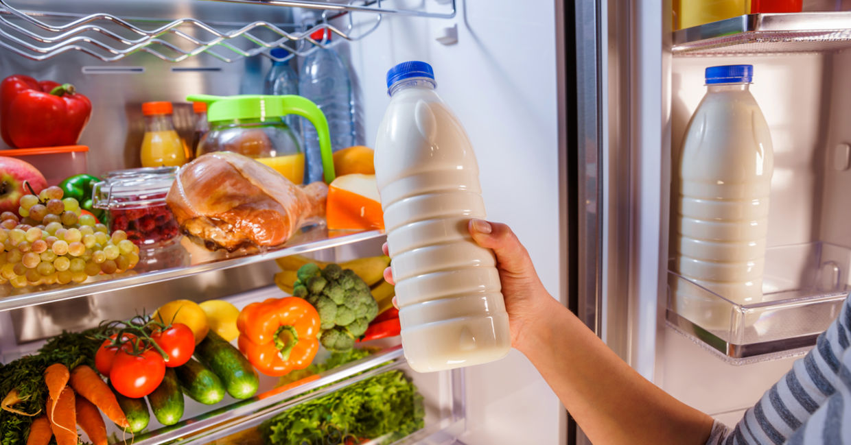 Woman checking on expiration date on milk.