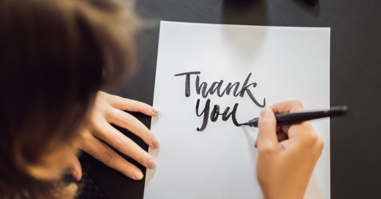 A woman shows gratitude by writing a thank you note.