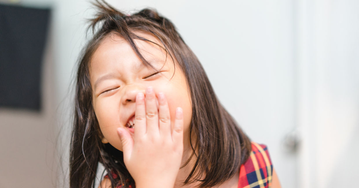 A little girl laughs with happiness.