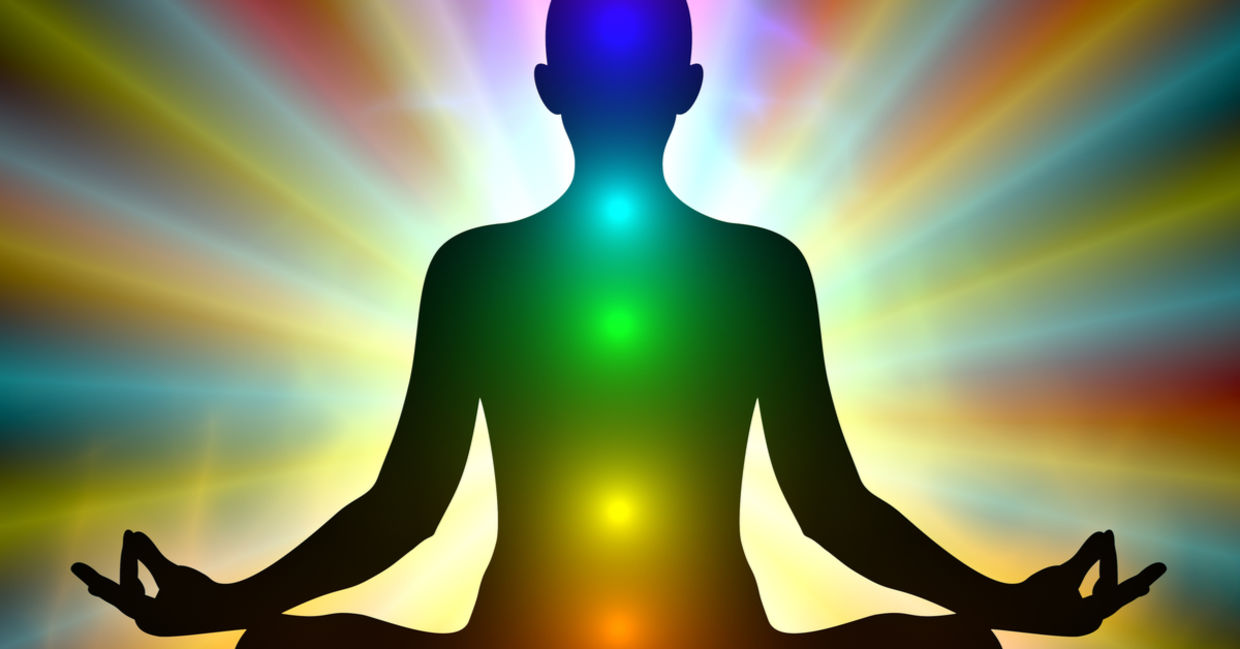 Aura colors and glowing chakras on a man who is meditating.