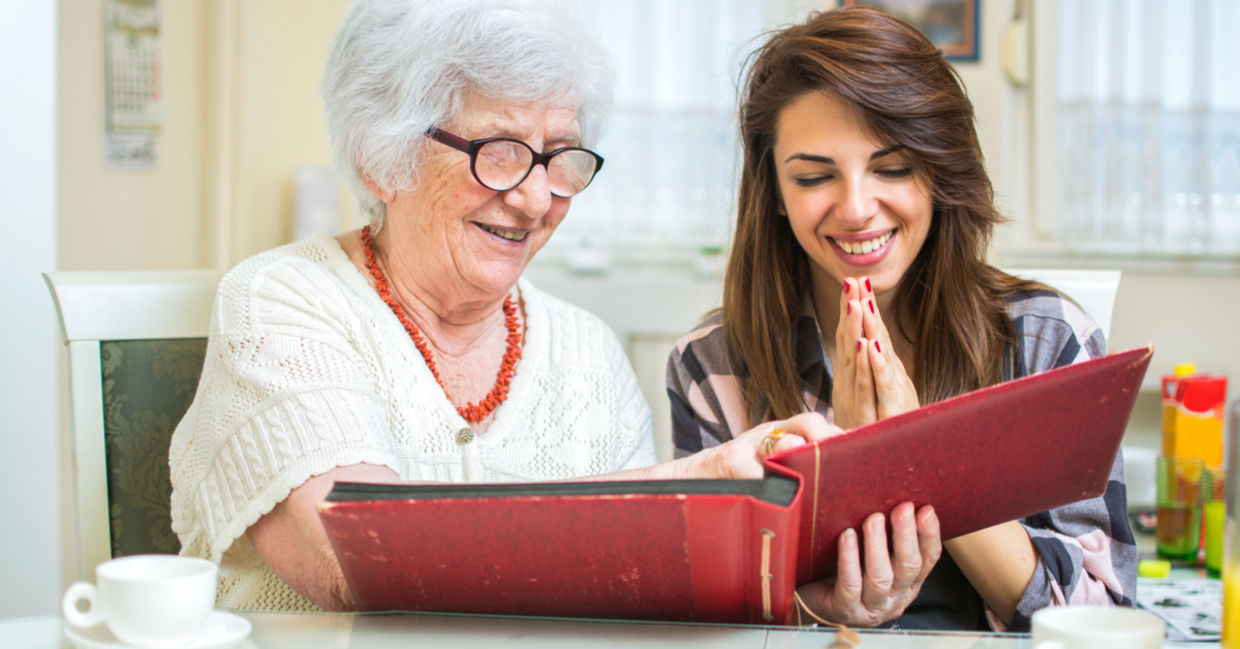 granddaughter looks at photos with grandmother