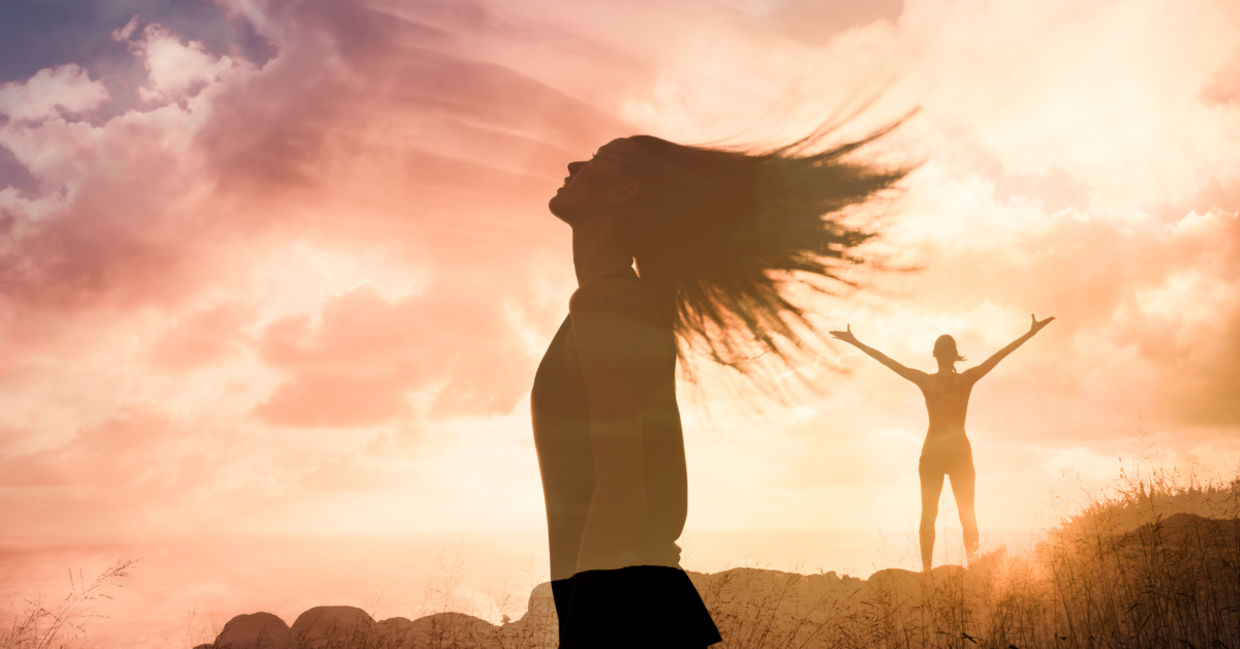 Woman triumphant at sunset