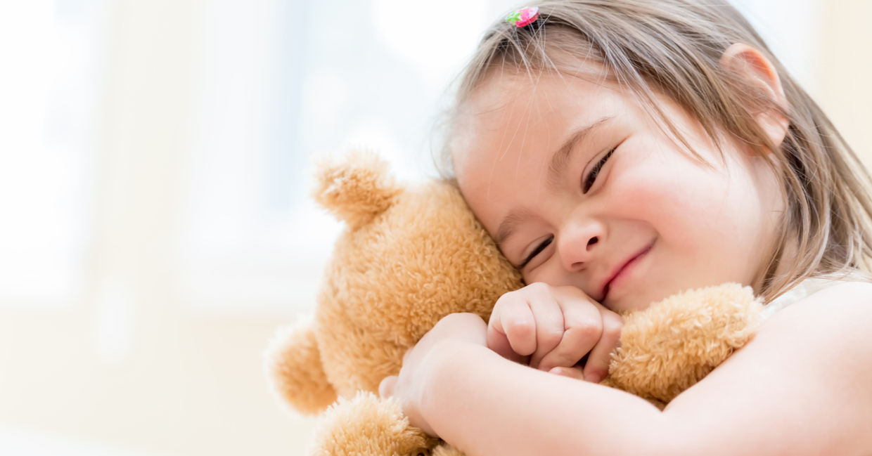 little girl hugging a teddy bear