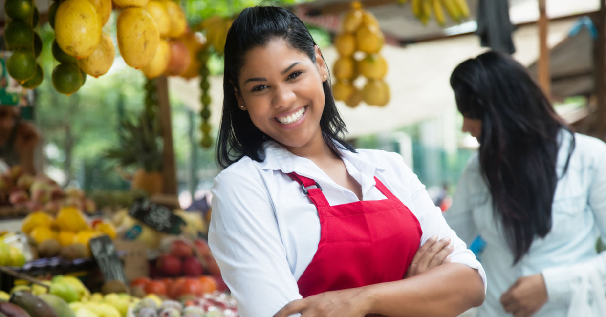 Latin American woman selling fruits and vegetables.