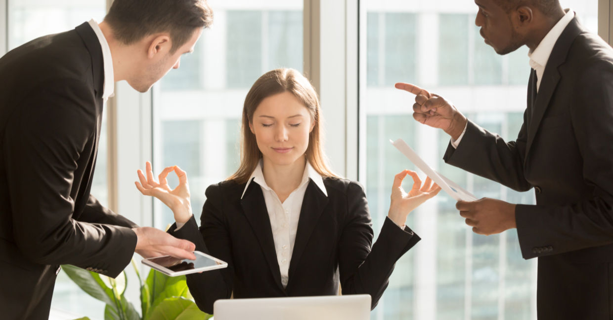 A businesswoman faced with conflict and pressure practices patience in the form of meditation.