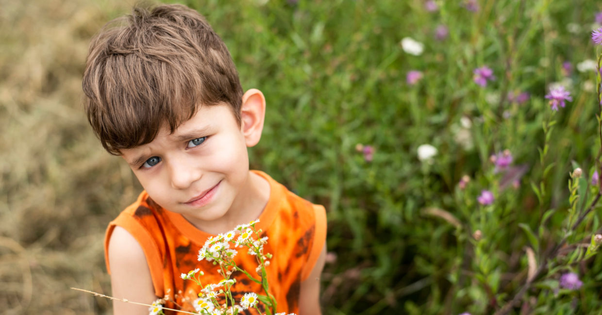 Boy giving mom flowers.