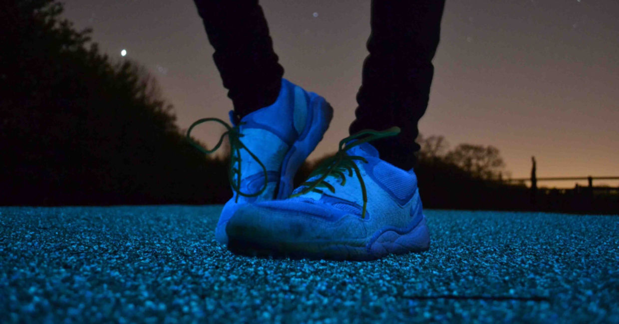 Jogger standing on solar-powered street lighting