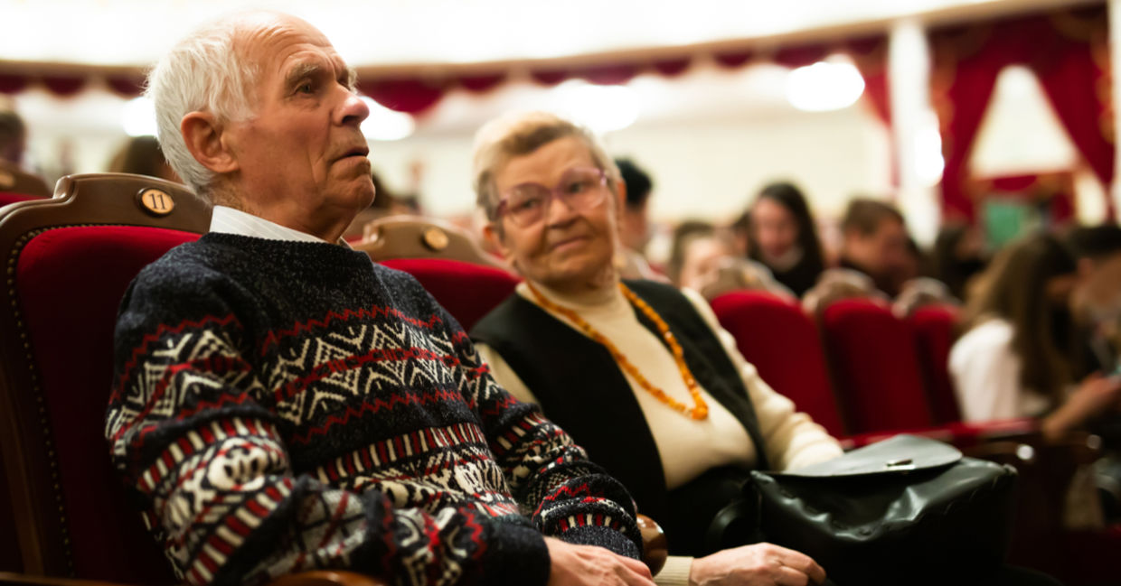 Senior couple enjoying performance at opera and ballet theater.