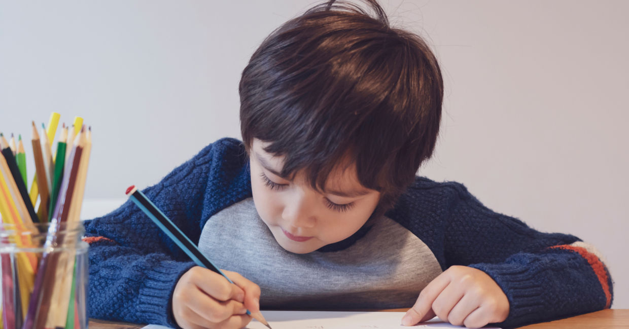 Child writing with a pencil.