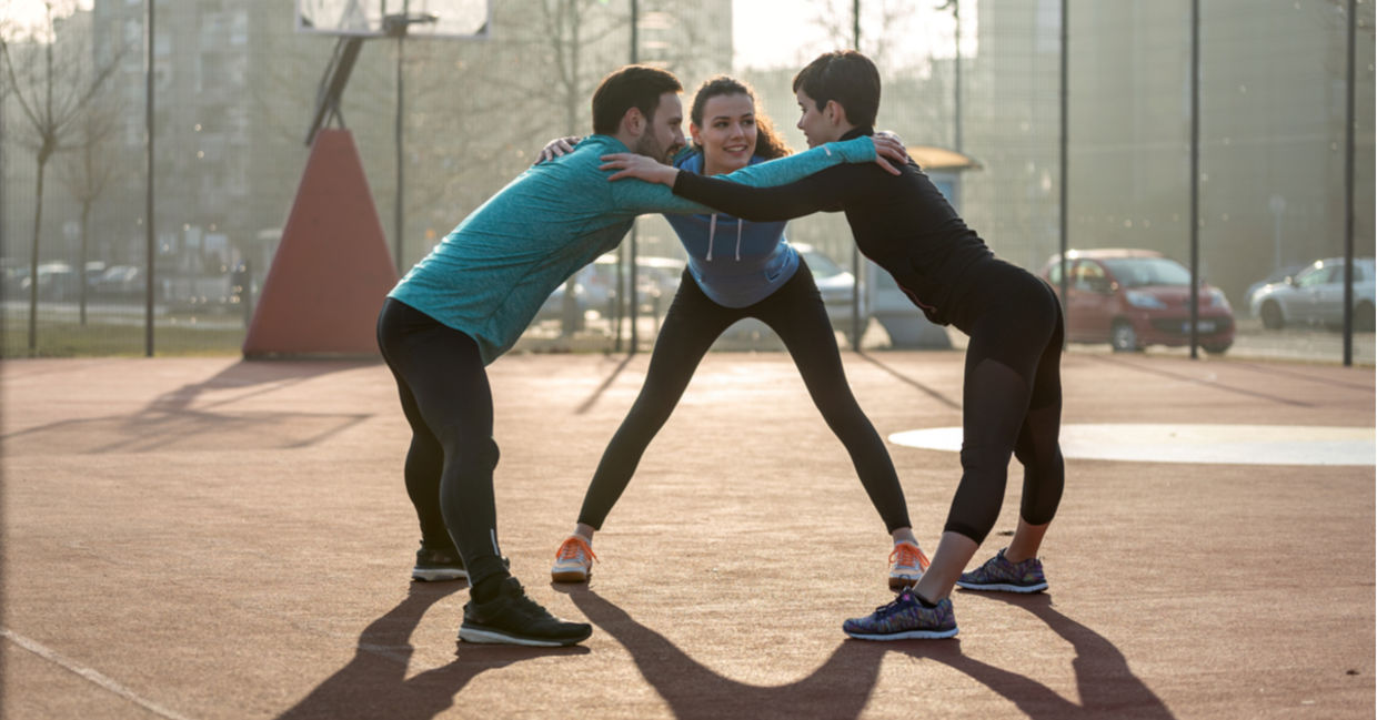 Three fitness friends huddle.
