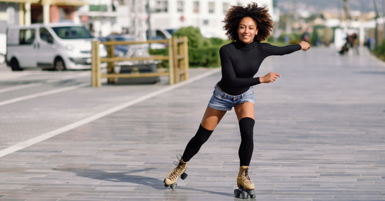 Young woman on roller skates riding outdoors in urban street