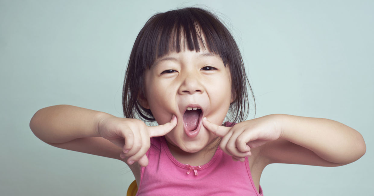 A young girl smiles.