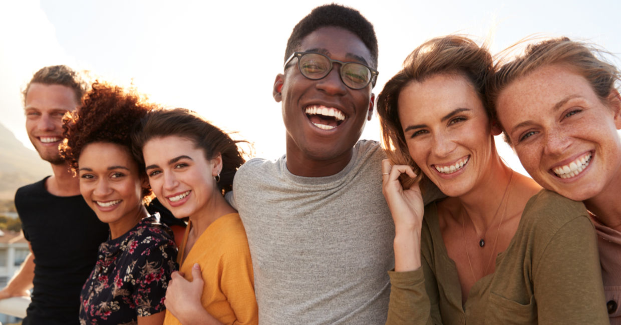 A group of young friends outside, smiling together.