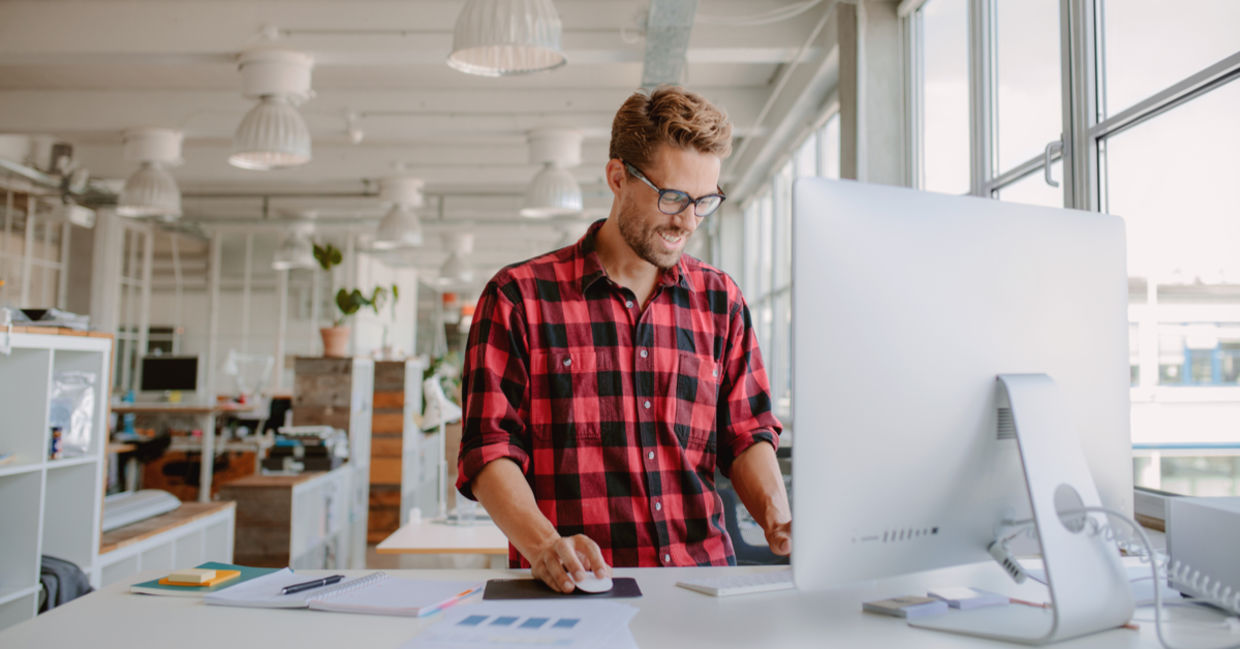 Happy young man working at a standing desk