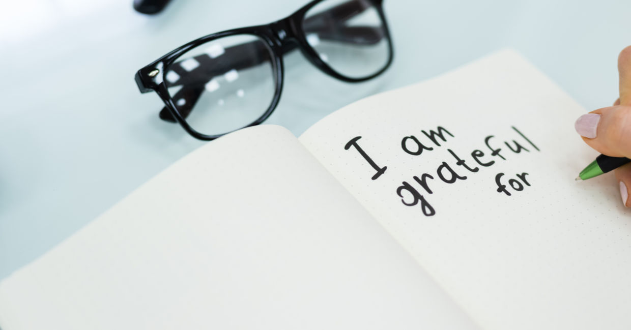 A woman writes in her gratitude journal.