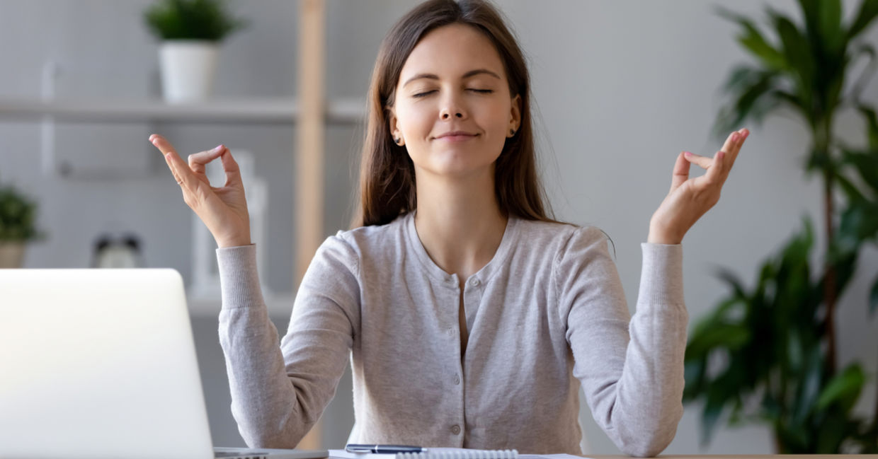 A woman takes a break from work to mediate and regain energy.