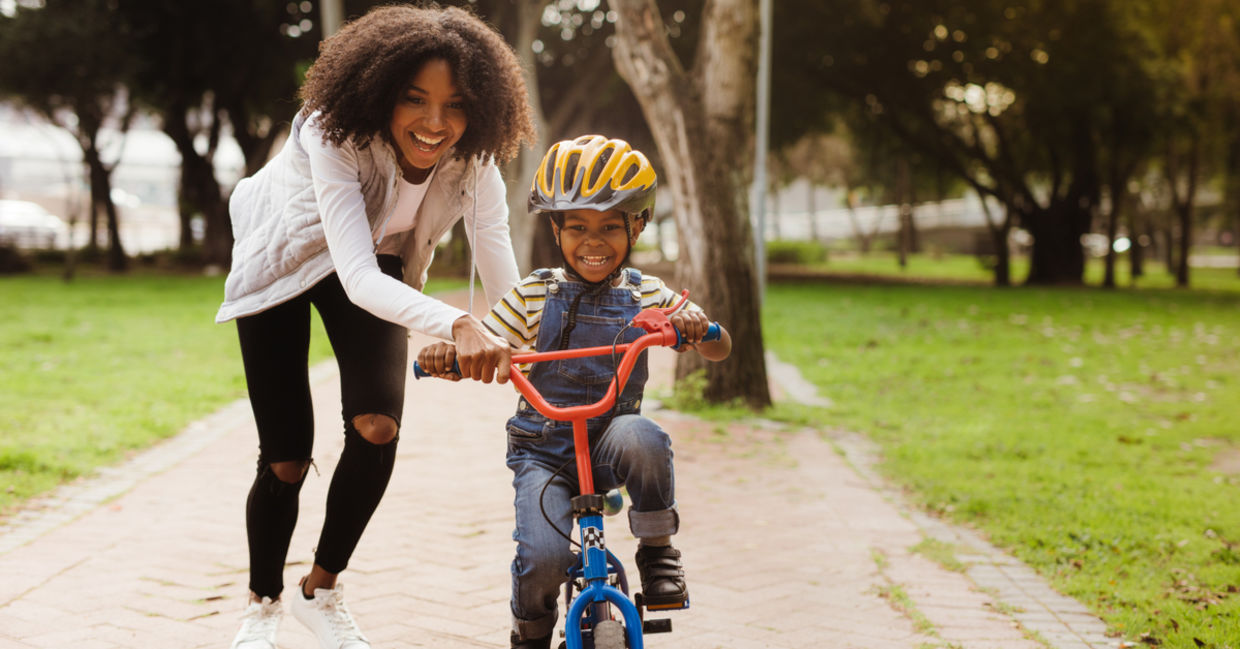 A mother teaching her child how to ride a bicycle.