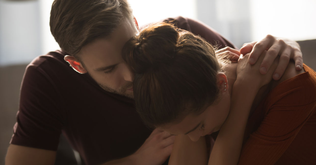 Tender man hugging stressed partner