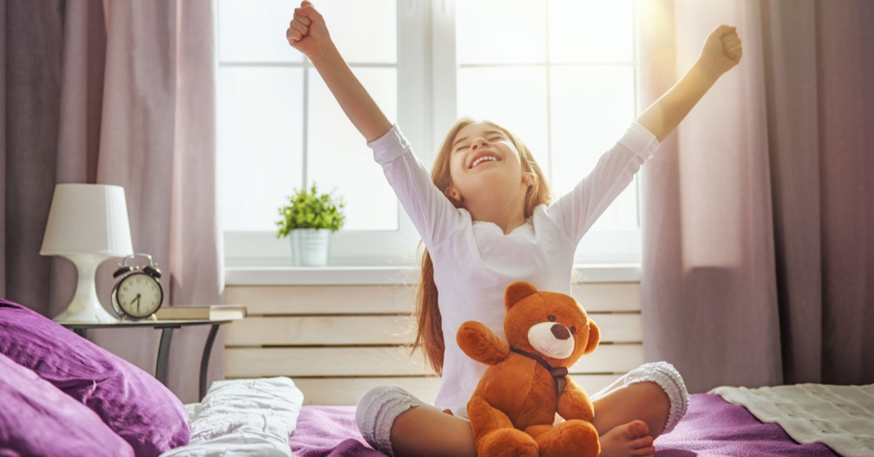 Young girl  happily waking up and stretching.