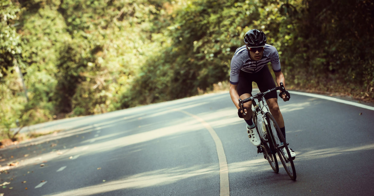 Man riding bicycle on road.