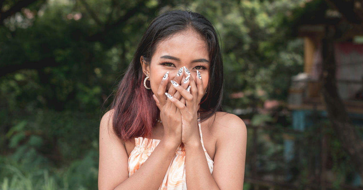 A young woman blushing.