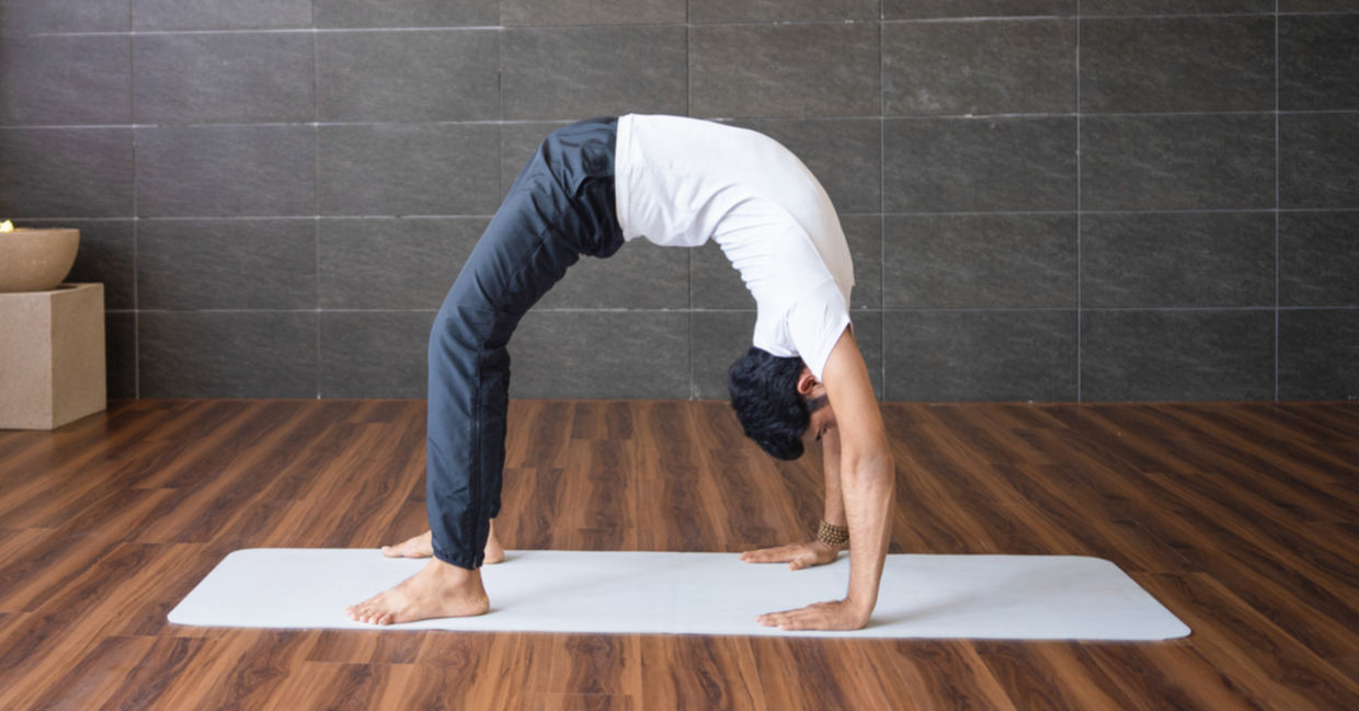 Man practicing the wheel yoga pose.