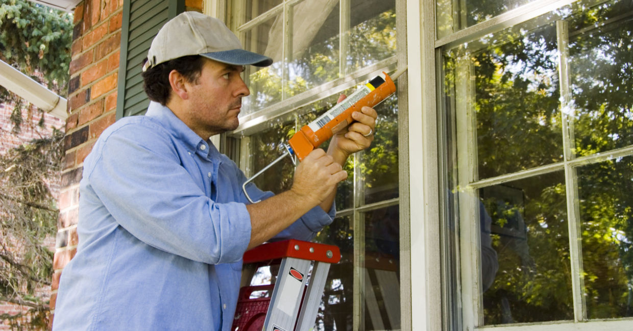 Caulking windows to keep heat in.