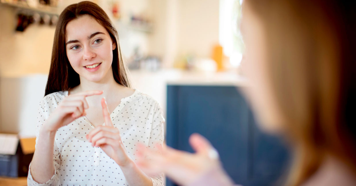 Two teenage girls having a conversation using sign language