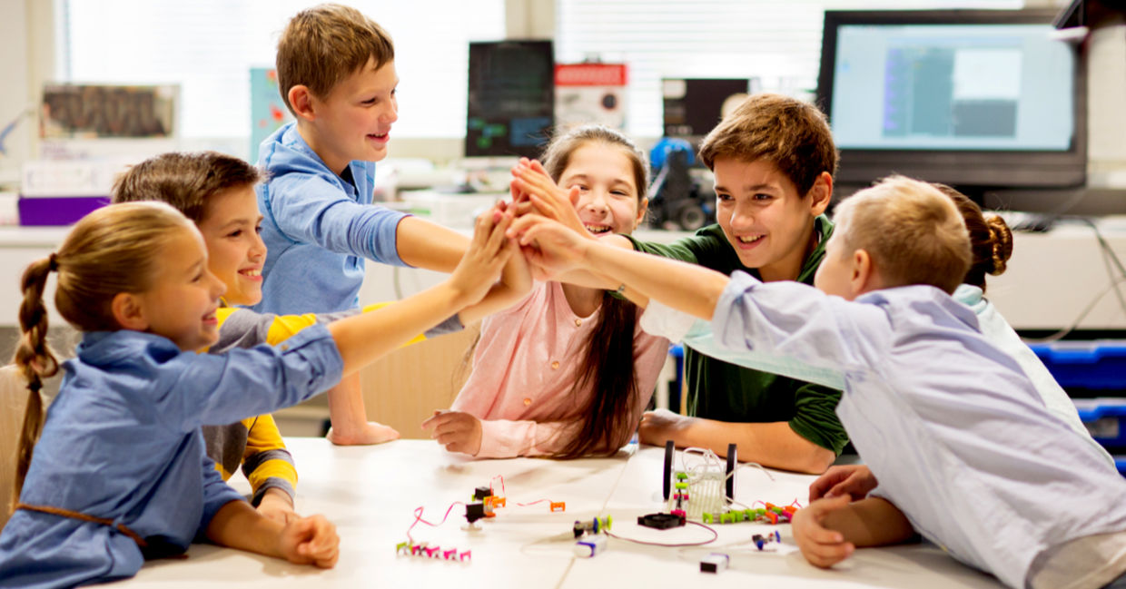 Happy children learning about tech at school