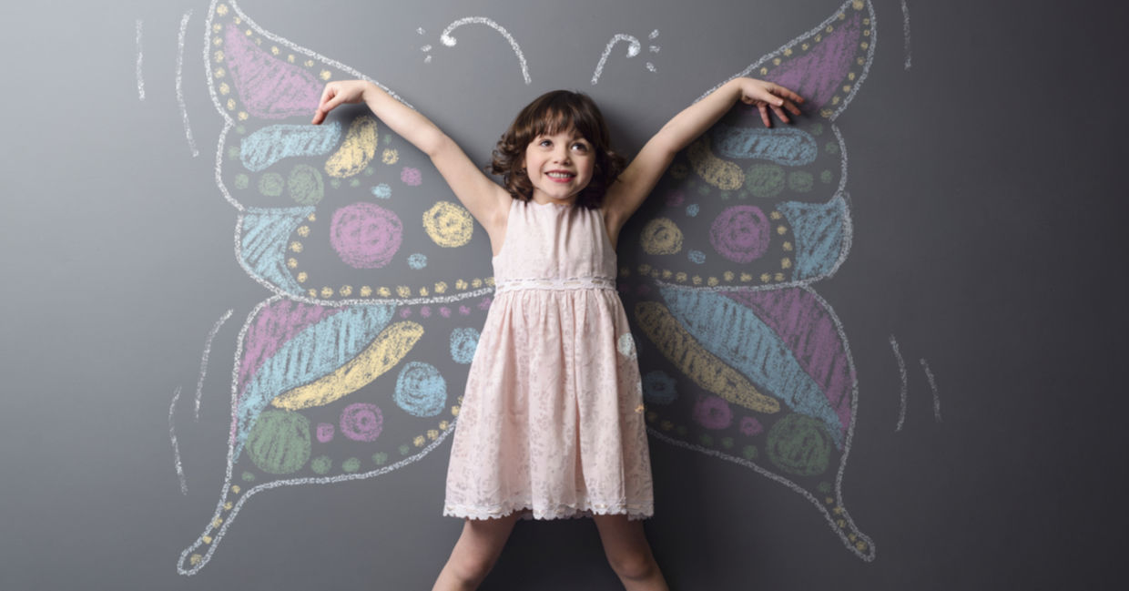 Little girl with a chalked butterfly behind her, a symbol of positive change and creativity.