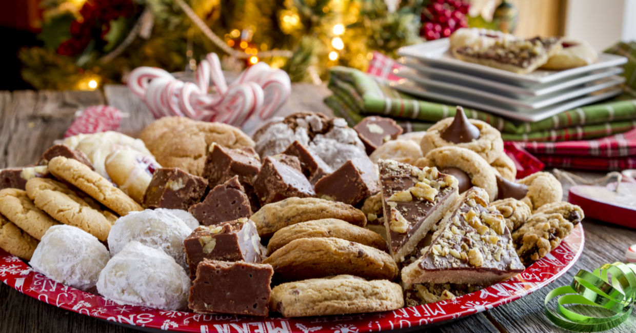 A plate of holiday treats in front of a Christmas tree.