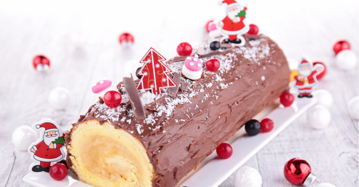A bûche de Noël or a yule log decorated with Santas.