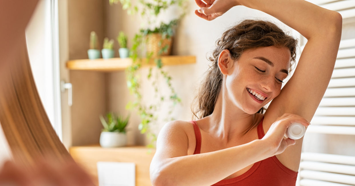 Woman using natural deodorant with tea tree oil.