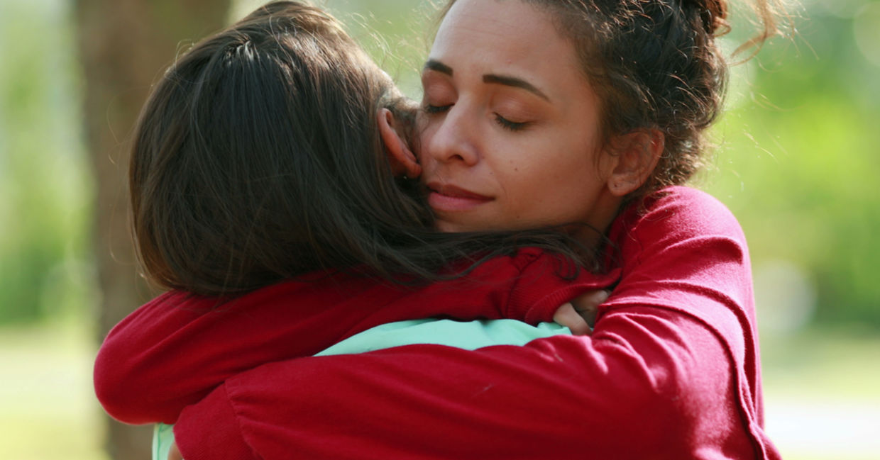 A woman shows forgiveness by embracing a family member.