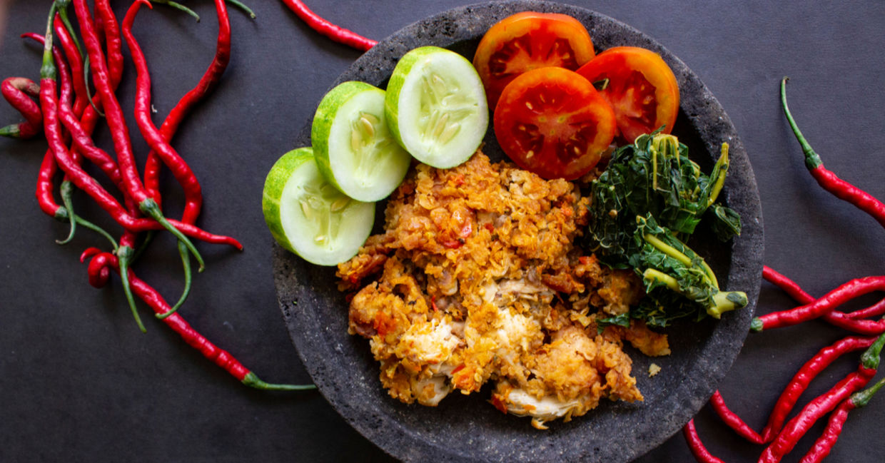 Ayam geprek or chicken crush, Indonesian food made from fried chicken pounded with chili and garlic flavor and served with vegetables and rice.