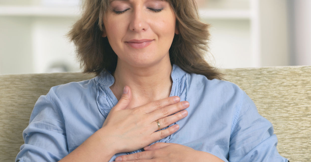 A woman practices self reiki to achieve a sense of inner harmony.