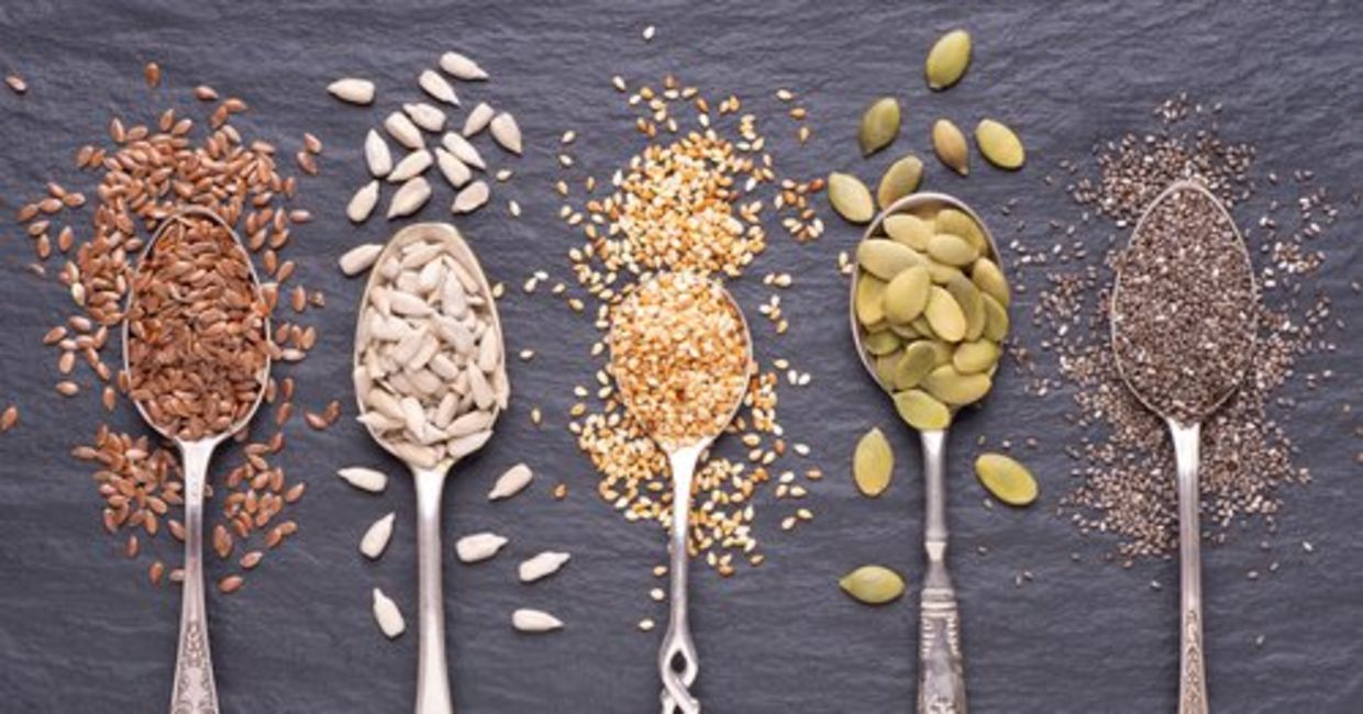 Spoons of healthy flax, chia, pumpkin, sunflower, and sesame seeds.