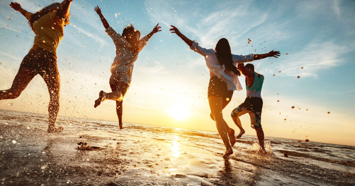 Four happy friends enjoying the beach.