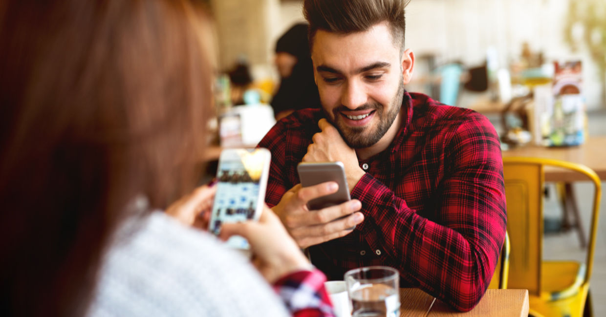 Couple using their mobile phones in a cafe.