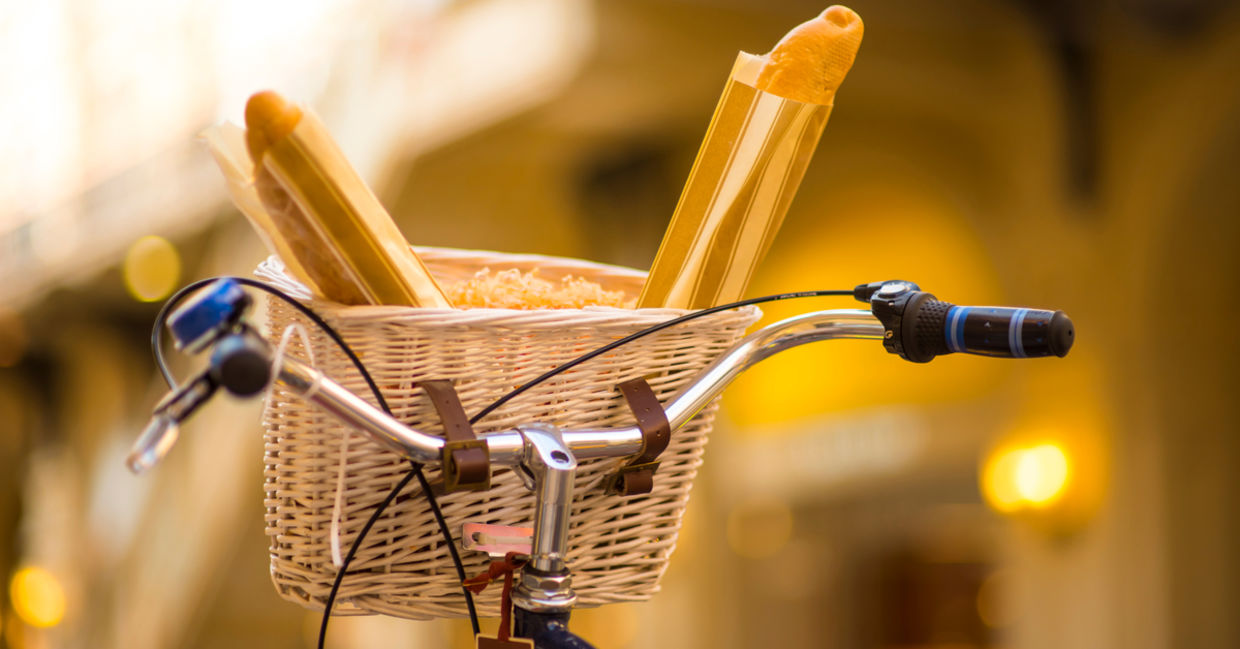 A basket with fresh goods on a bicycle.