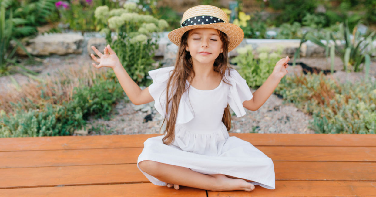 Girl relaxing near a flower bed.