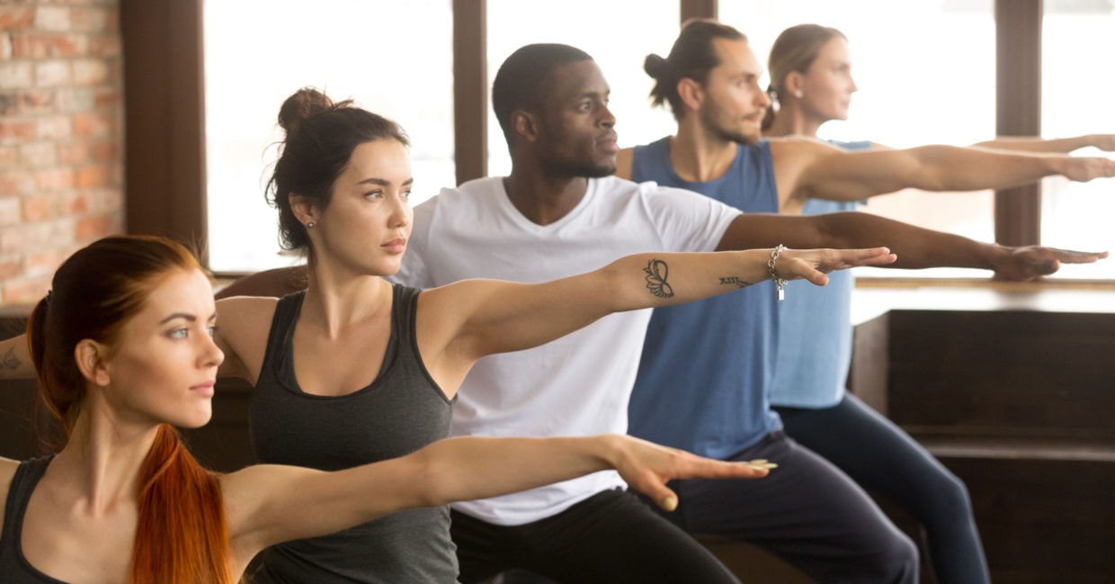 Yoga class in Warrior II yoga pose.