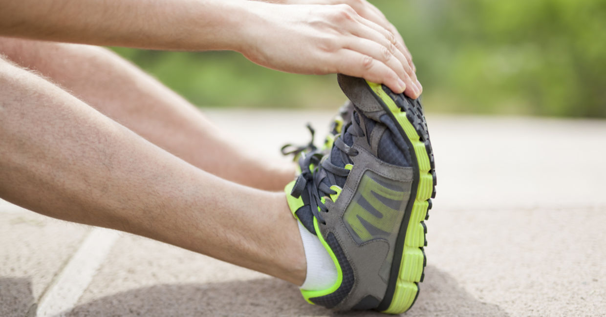 An athlete doing foot stretches to prevent injuries