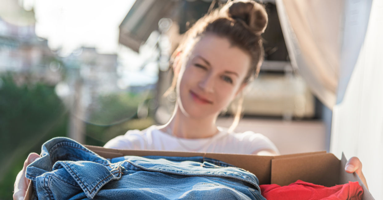 Young woman donating preloved clothing.