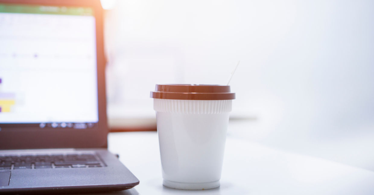 Hot espresso on the desk by a laptop computer to help with focus.