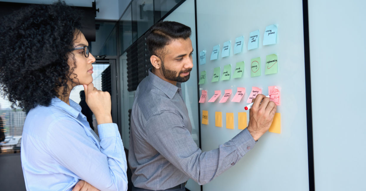 Businessman writing color-coded strategy ideas.