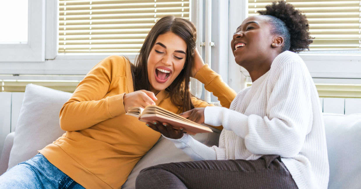 Two women laughing while learning together.
