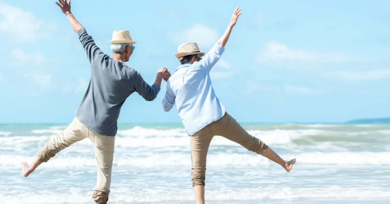 Seniors having fun during a beach walk.