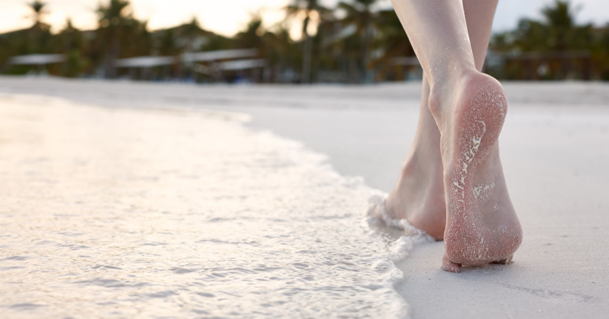 As a woman strolls on the beach, her body enjoys a gentle workout.